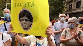 A demonstrator holds a portrait of Carles Puigdemont, during a demonstration in front of the Italian consulate in Barcelona.