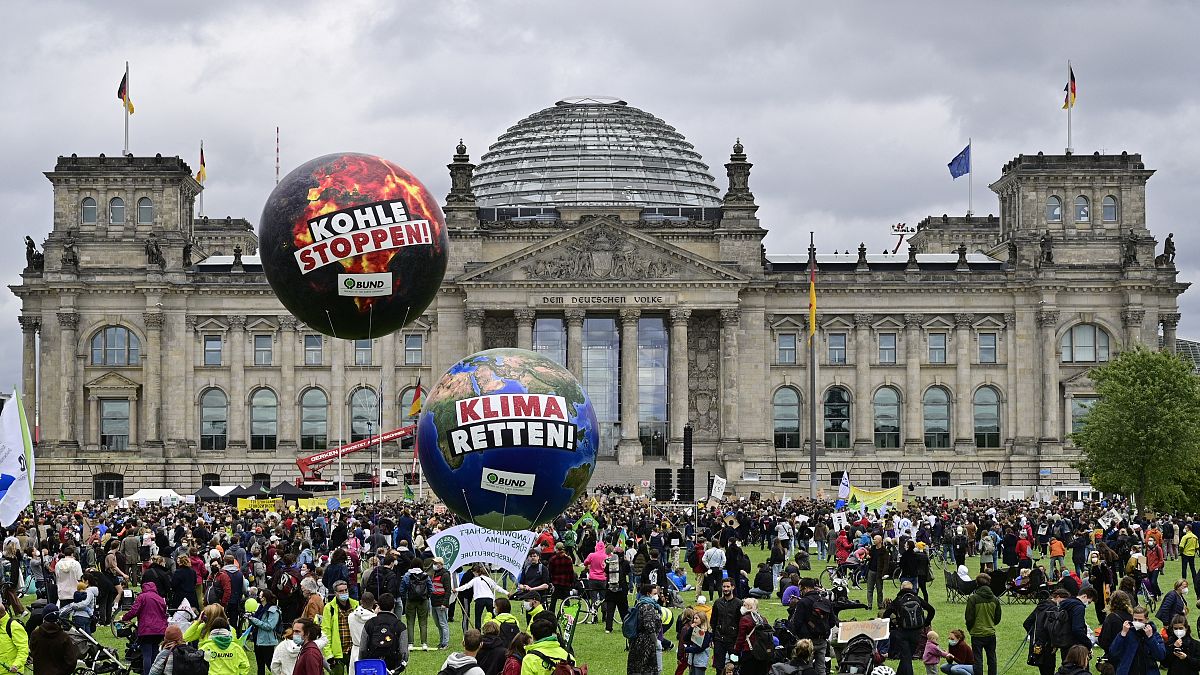 Demonstrators stand in front of the Reichstag building during a Fridays for Future global climate strike in Berlin.