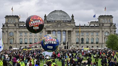 Demonstrators stand in front of the Reichstag building during a Fridays for Future global climate strike in Berlin.