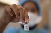 Malezya'da bir sağlık çalışanı Coronavac şişesi tutuyor