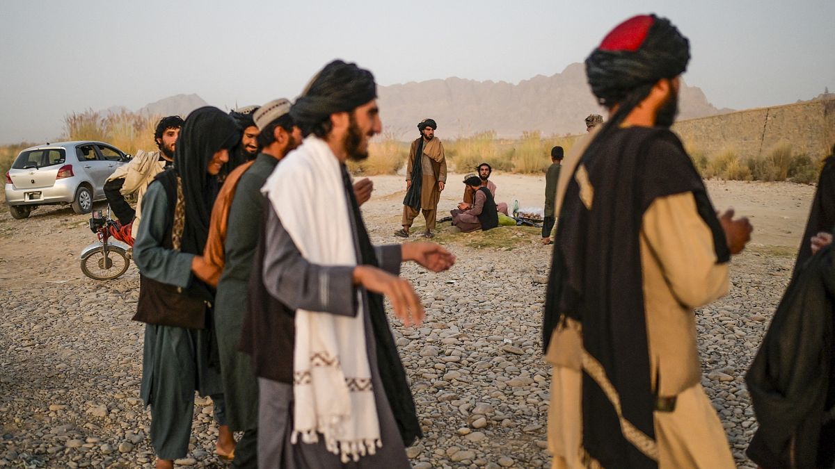 Taliban members enjoy a traditional dance on the banks of a river in Kandahar. 