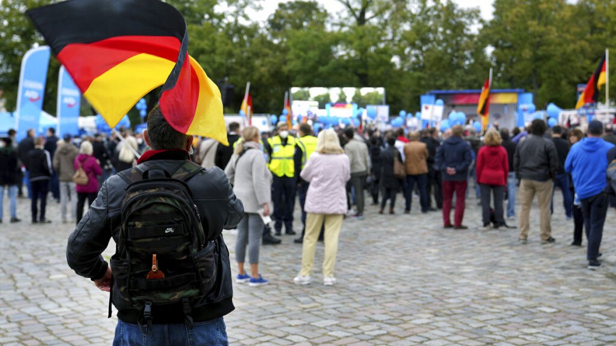 People attend an election campaign event of the Alternative for Germany party (AfD) in front of the Charlottenburg palace in Berlin, Germany, Friday, Sept. 24, 2021.