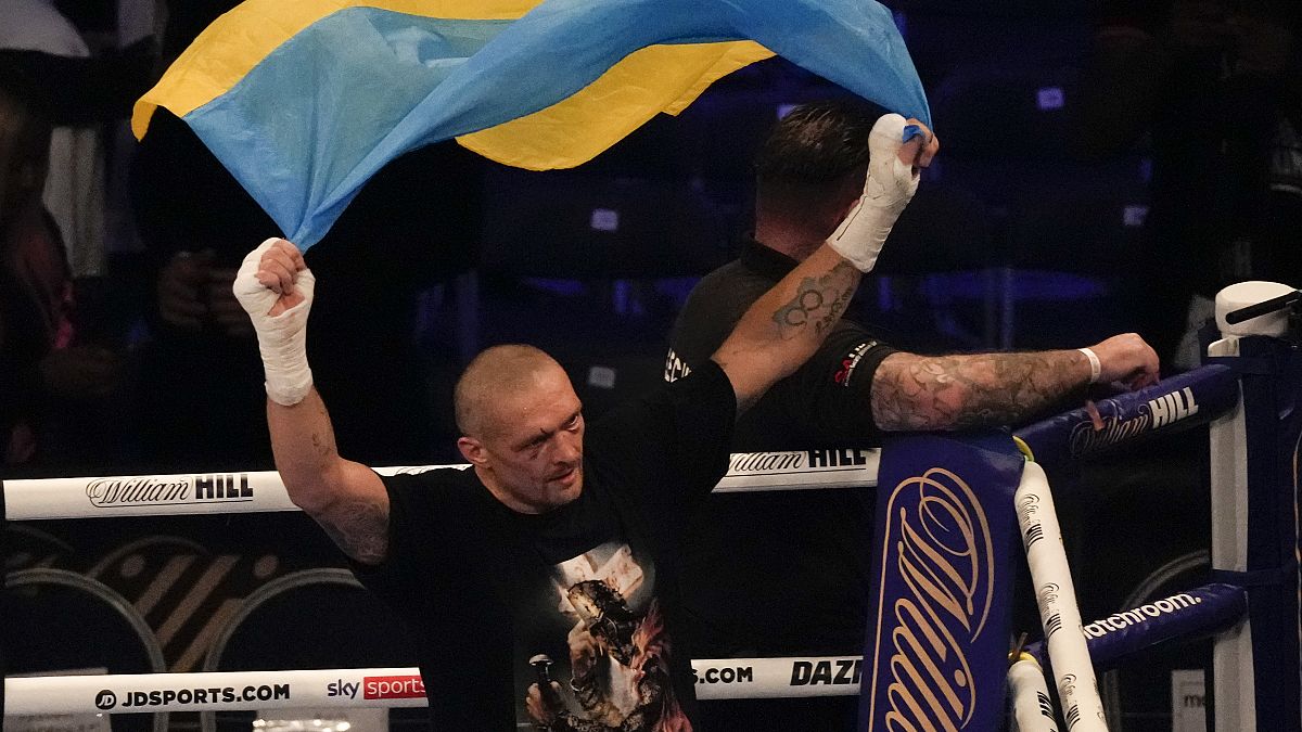 Oleksandr Usyk of Ukraine holds up the Ukrainian flag after his unanimous decision victory over Anthony Joshua of Britain, in London, Sept. 25, 2021.