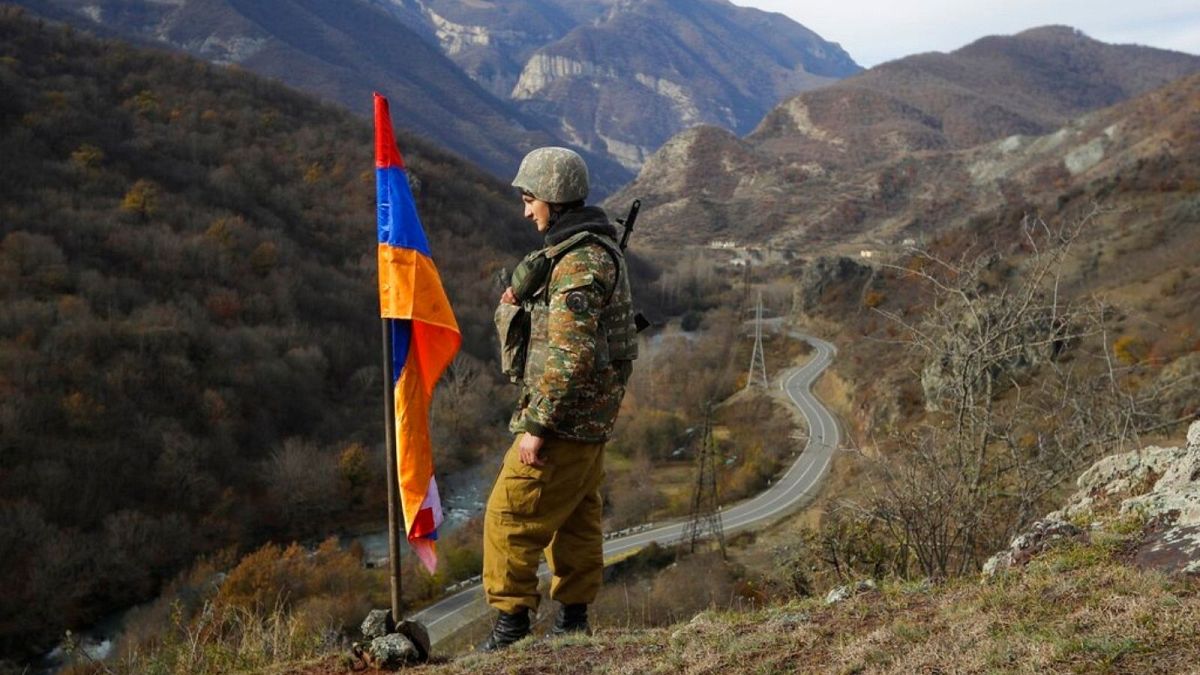 An ethnic Armenian soldier stands guard next to Nagorno-Karabakh's flag