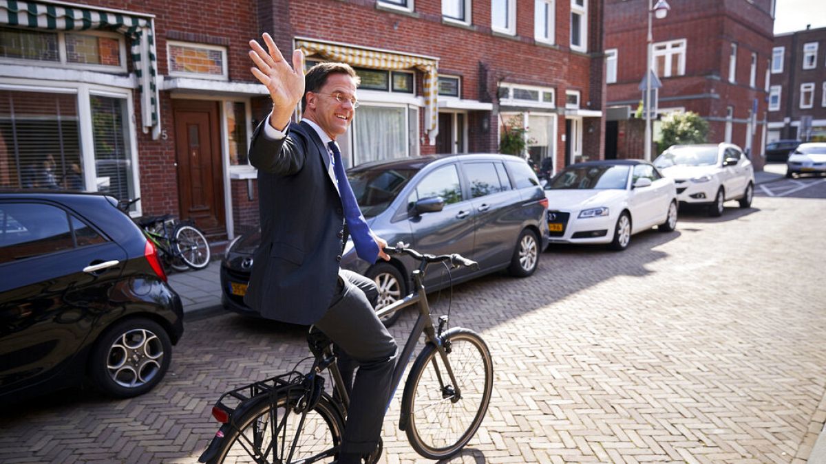 Netherlands Prime Minister Mark Rutte leaves on his bike after voting in the European elections in The Hague, Netherlands, Thursday, May 23, 2019