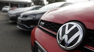 Display cars are parked at a Volkswagen dealership.