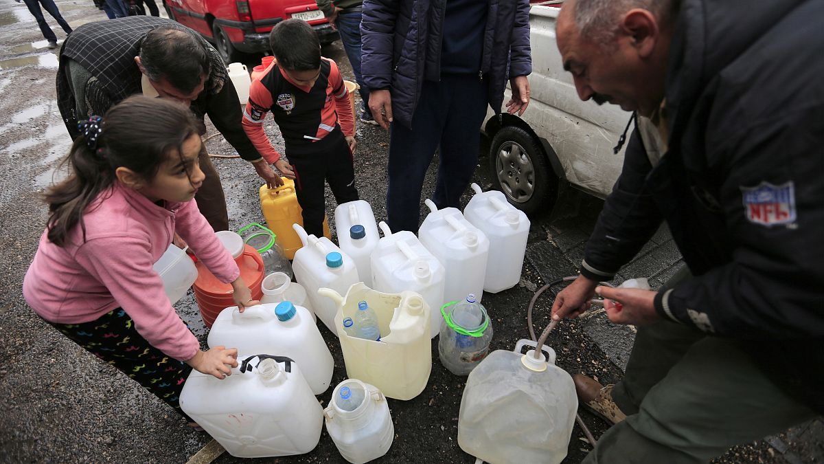 أشخاص يملأون أوعية بلاستيكية بمياه من صنبور ماء في دمشق، سوريا ، الاثنين ، 16 يناير / كانون الثاني 2017.