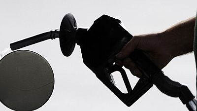 A motorist pulls the nozzle out of his gas tank after fueling his car at a station in Augusta, Maine, on Monday, Aug. 15, 2011