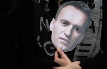 A mask of Russian opposition leader Alexei Navalny is held at a rally in Berlin.