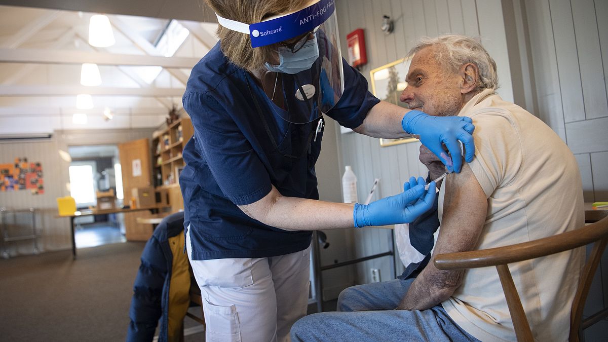 A health worker administers a Pfizer's COVID-19 vaccine to a man at a temporary vaccination clinic in a church in Sollentuna, Sweden, Tuesday March 2, 2021.