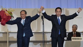 New Japanese Prime Minister Fumio Kishida, right, celebrates with outgoing Prime Minister Yoshihide Suga in Tokyo on September 29, 2021.