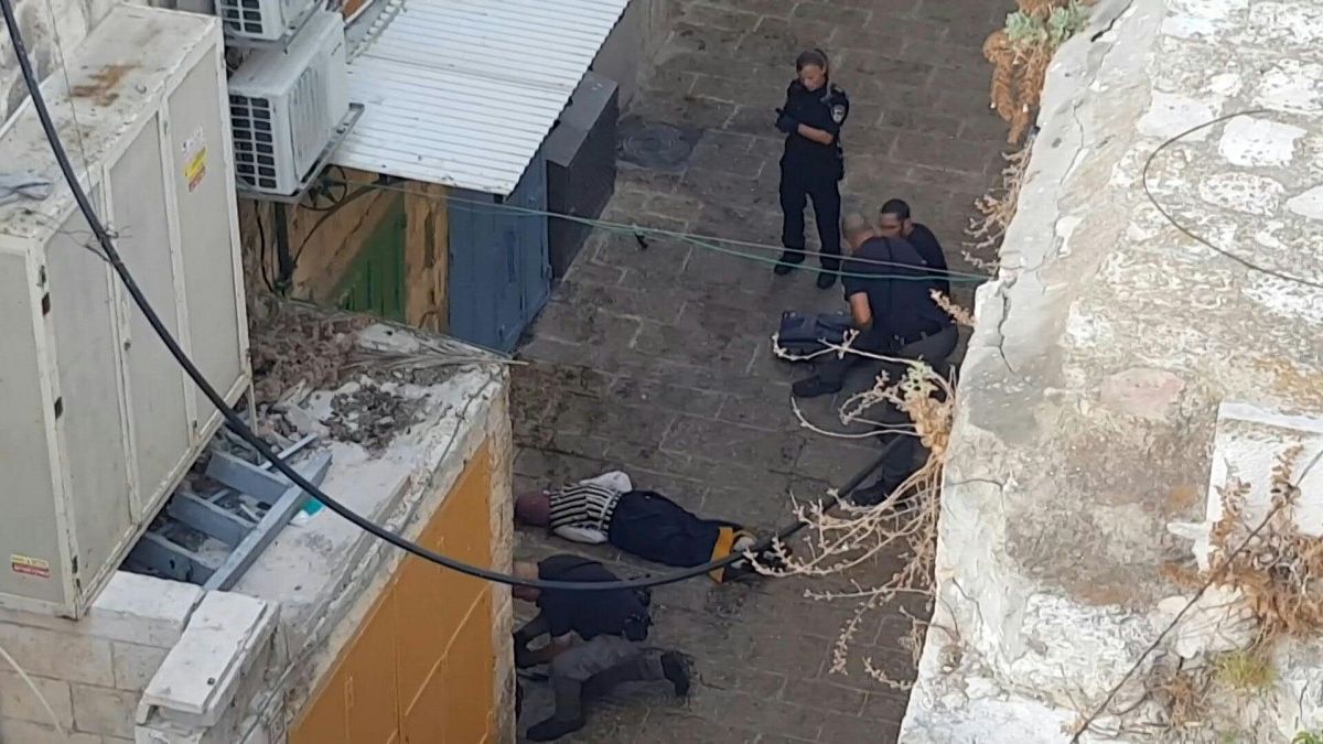 القوات الإسرائيلية أمام جثة امرأة أطلقوا النار لمحاولتها طعن ضباط في مدينة القدس القديمة.
