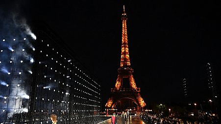 Models presenting creations by Saint Laurent with the Eiffel tower in the background during the Paris Fashion Week on September 28, 2021.
