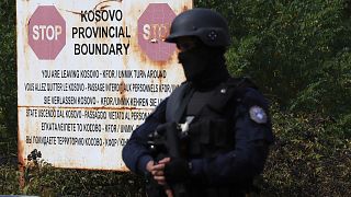 A Kosovo special police officer stands on the road near the northern Kosovo border crossing of Jarinje, Sept. 20, 2021. 