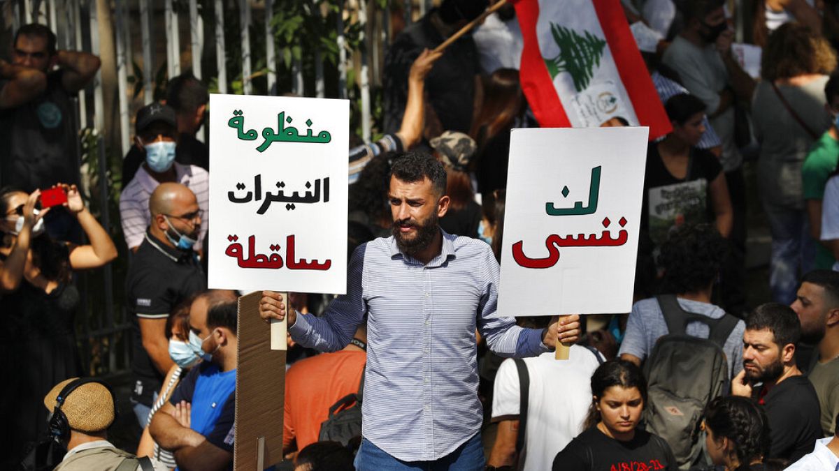 متظاهر يحمل لافتات خارج مبنى المحكمة خلال مظاهرة تضامن مع القاضي طارق بيطار الذي يحقق في انفجار ميناء بيروت، في بيروت، لبنان، الأربعاء 29 سبتمبر 2021