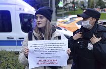 A police officer detains a journalist holding a banner that reads: "There are no foreign agents, there are journalists," in Moscow, Russia, Sept. 8, 2021.