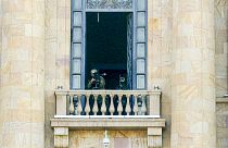 A security agent points a sniper rifle from a window of the Armenia parliament building.