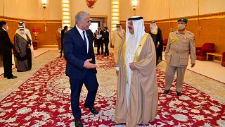 Israel's Foreign Minister Yair Lapid, walks with Bahraini King Hamd bin Issa al Khalifa