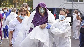 Medical staff support a patient breathing through an oxygen mask after a fire in the COVID-19 ICU section of the Hospital for Infectious Diseases in Constanta