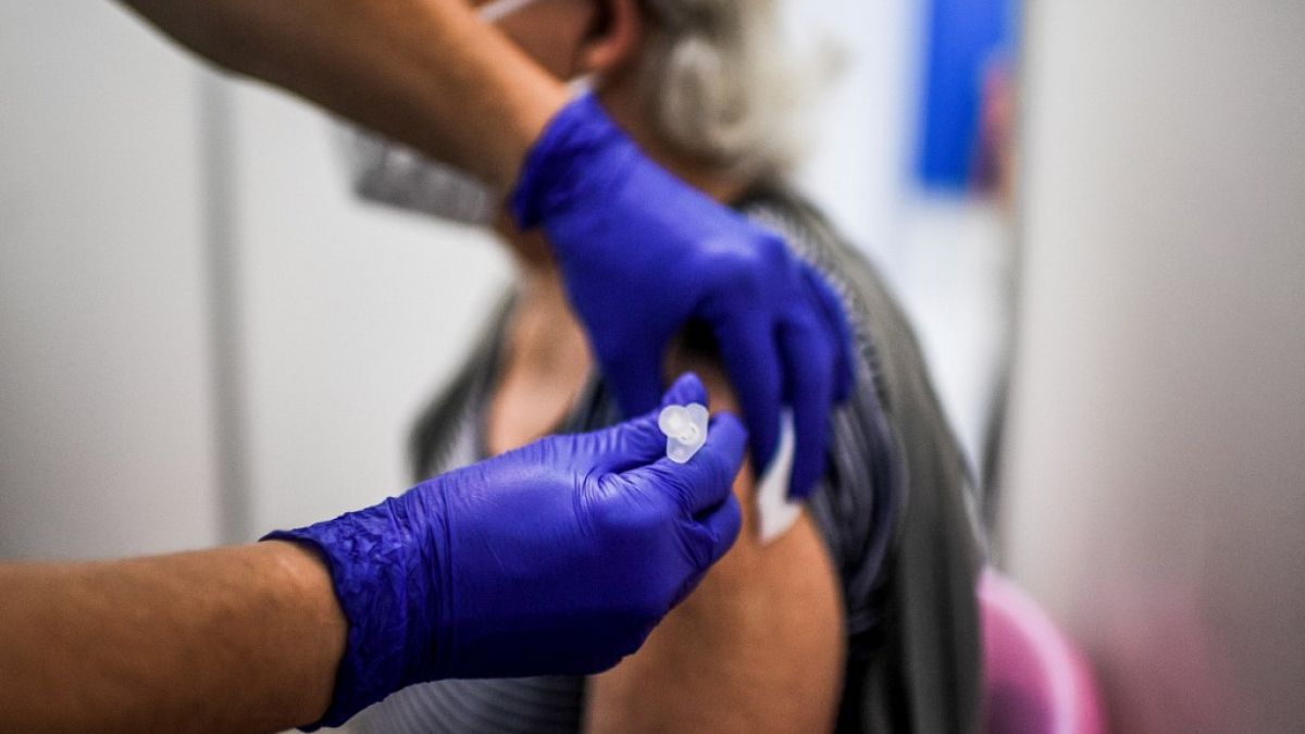 A healthcare worker administers a dose of a Covid-19 vaccine to a man at a vaccination center in Lisbon on July 2, 2021.