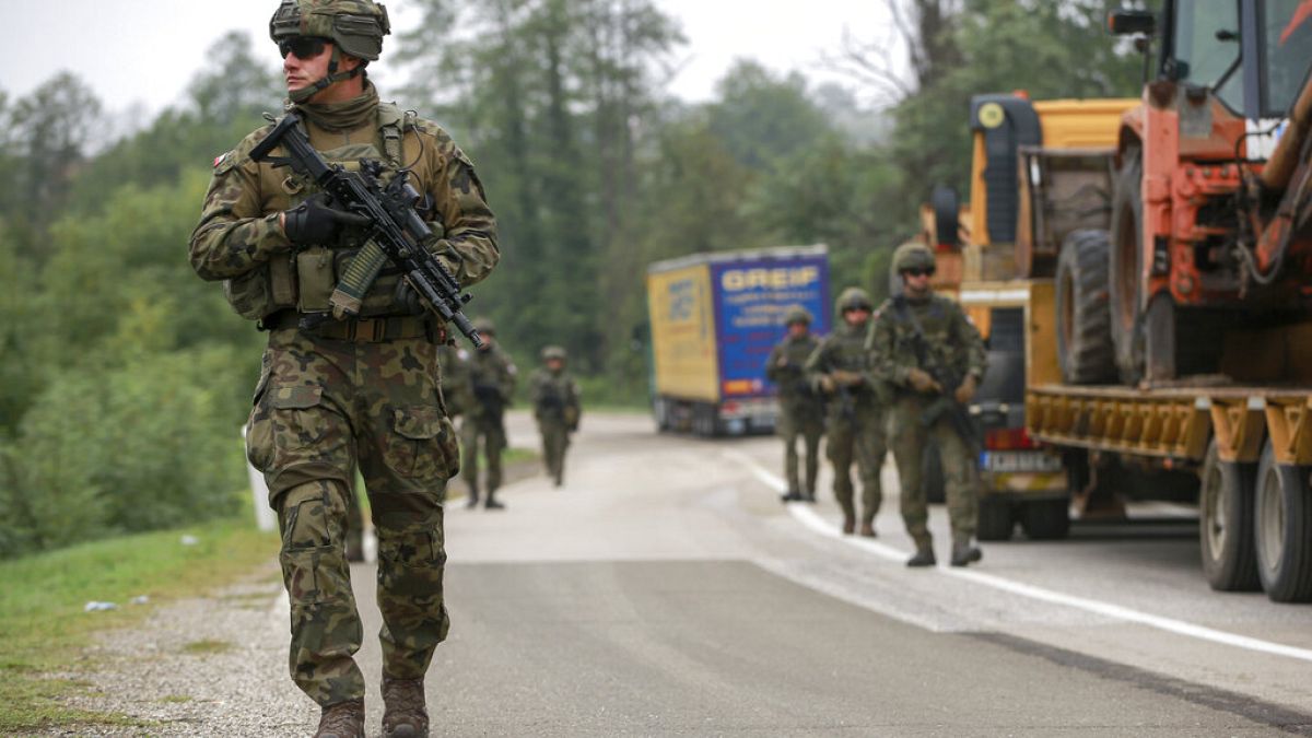 Polish soldiers, part of the peacekeeping mission in Kosovo KFOR, pass through barricades as they patrol near the crossing at Jarinje, Kosovo-Serbia border, October 2, 2021.
