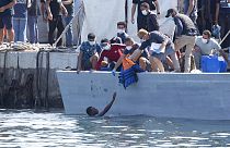Un homme demande de l'aide, sur l'île italienne de Lampedusa, Italie, le 3 octobre 2021