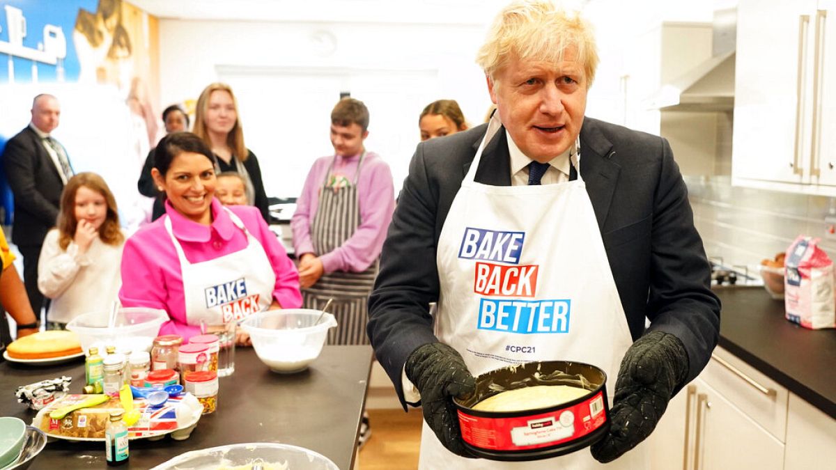 Britain's Prime Minister Boris Johnson and Home Secretary Priti Patel try baking during a visit to HideOut Youth Zone, in Manchester, England, Sunday Oct. 3, 2021.