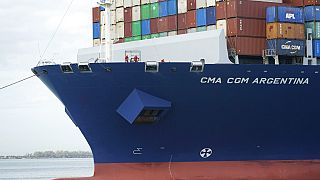 In this April 6, 2021 photo, crew members stand on the bow as the CMA CGM Argentina arrives at PortMiami, the largest container ship to call at a Florida port in Miami