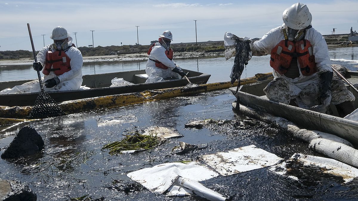 عمال يحاولون تنظيف المياه بعد تسرب للنفط في شاطئ كاليفورنيا الأمريكية