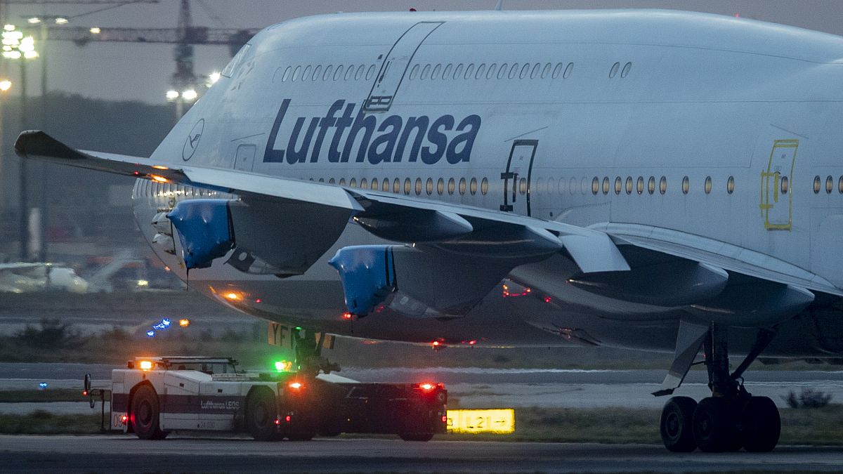 A Lufthansa Boeing 747 with covered engines is pulled to a parking position at the airport in Frankfurt, Germany, Oct. 22, 2020.