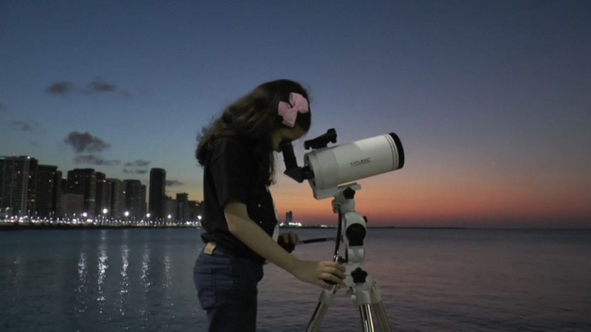 Nicole Oliveira observando a través de un telescopio, 22/9/2021, Fortaleza, Brasil