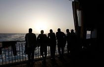 مهاجران روی یک کشتی نجات به دریای مدیترانه خیره شده‌اند