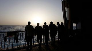 مهاجران روی یک کشتی نجات به دریای مدیترانه خیره شده‌اند