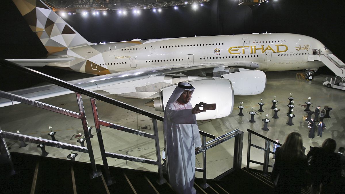 رجل إماراتي يلتقط صورة سيلفي أمام طائرة الاتحاد للطيران الجديدة A380 في أبو ظبي، الإمارات العربية المتحدة.