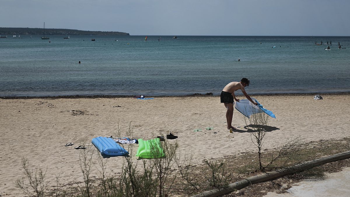 A sunbather enjoys the beach in the Balearic Islands capital of Palma de Mallorca, Spain, July 29, 2020.