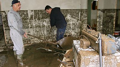 People clean the inside of their house in Marseille, following devastating floods. 