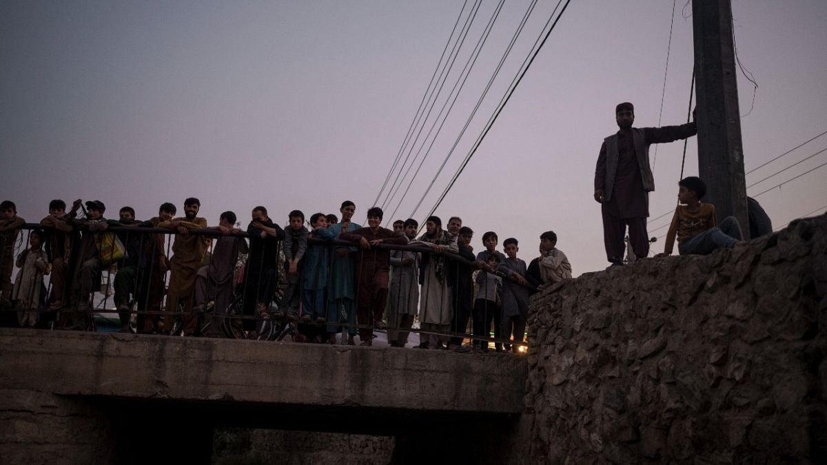 أفغان يتجمعون لمشاهدة مقاتلي طالبان وهم يحتجزون متعاطي المخدرات خلال عملية للشرطة في كابول، الجمعة 1 أكتوبر 2021