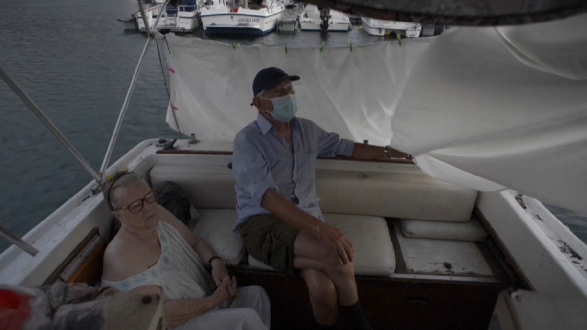 Luis y Margeritte se refugian del volcán en su lancha en el puerto de Tazacorte, La Palma
