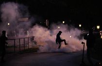 A demonstrator stomps on a smoke canister during the protest in Ljubljana.