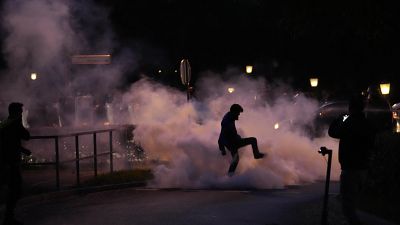 A demonstrator stomps on a smoke canister during the protest in Ljubljana.