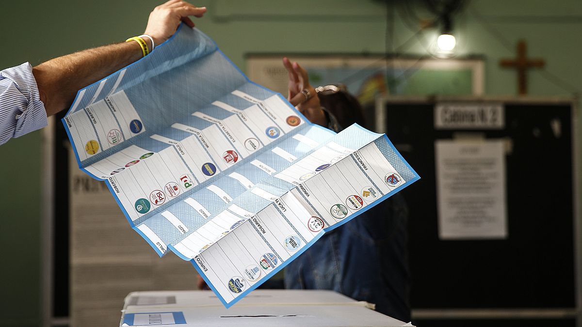 A man receives his ballots at a polling station in Rome.