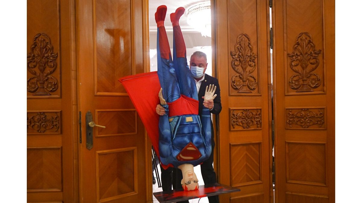 A román kormányt megbuktató parlamenti szavazás előtt Superman figuráját viszi ki valaki az ülésteremből