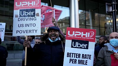 People take part in an Uber drivers' protest outside the company's offices in east London, Wednesday, Oct. 6, 2021.