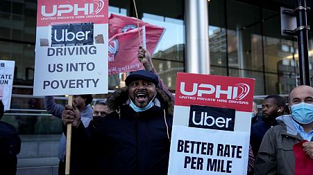 People take part in an Uber drivers' protest outside the company's offices in east London, Wednesday, Oct. 6, 2021.