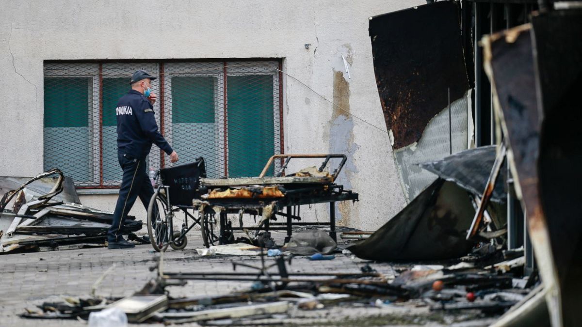 A police officer walks past burned hospital equipment on the site of the fire.
