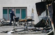 A police officer walks past burned hospital equipment on the site of the fire.
