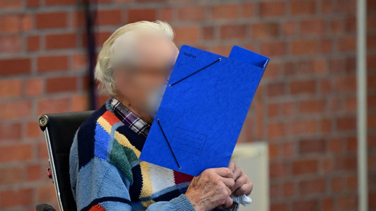 Defendant Josef S hides his face behind a folder as he waits for the start of his trial in Brandenburg an der Havel, northeastern Germany, on October 7, 2021.