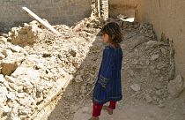 Une fillette regardant une maison endommagée après le tremblement de terre à Harnai, à environ 100 kilomètres à l'est de Quetta, au Pakistan, jeudi 7 octobre 2021.