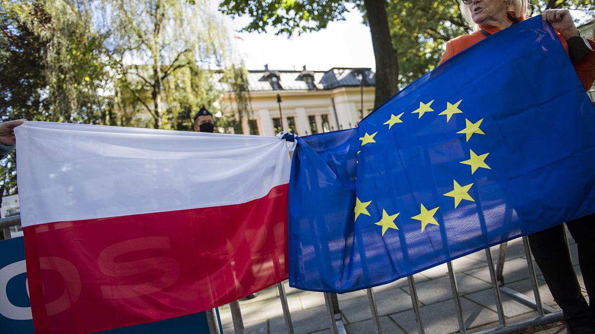 Protesters hold Polish and EU flags tied together during a demonstration outside the Constitutional Tribunal.