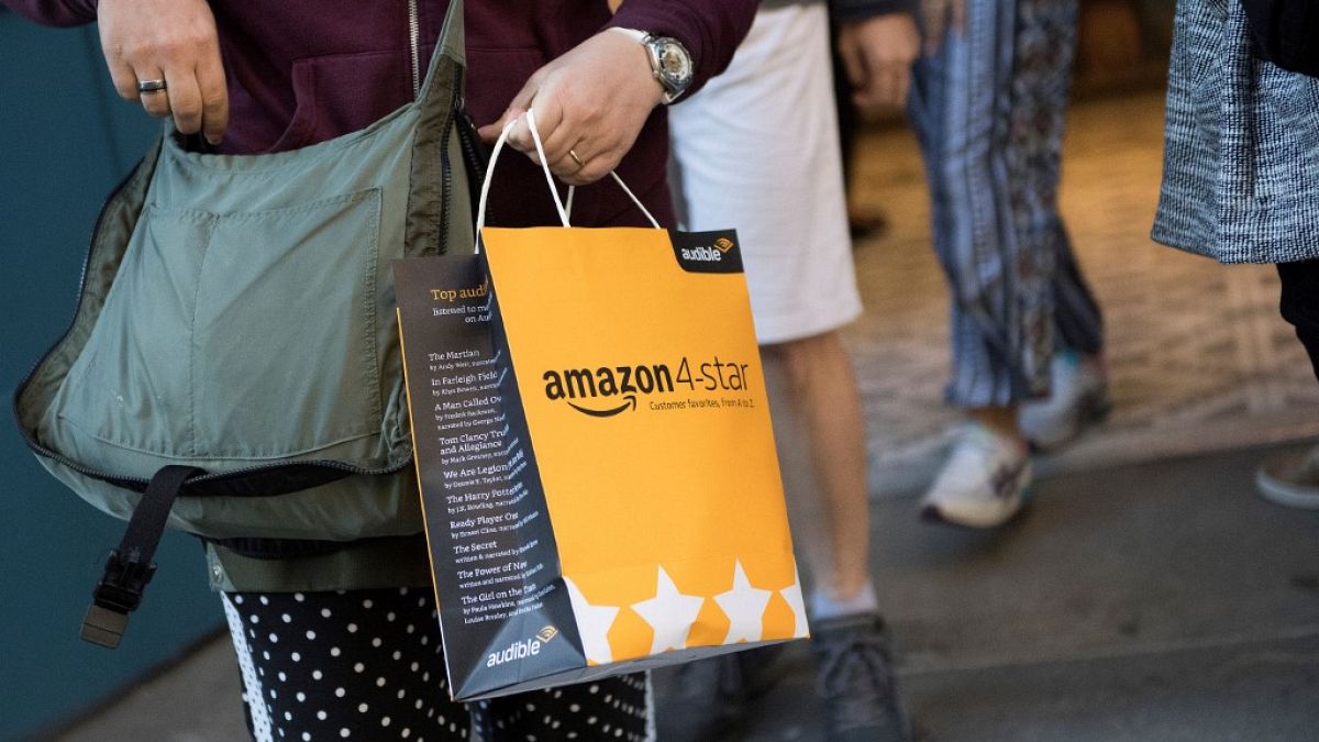 A customer carries a bag as they leave a new Amazon store where everything for sale is rated 4 stars and above.